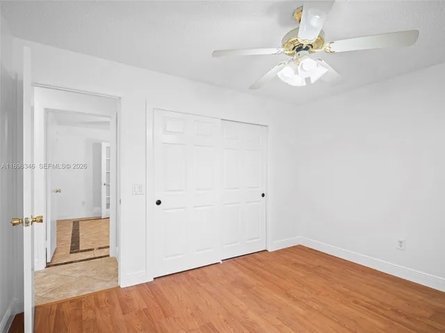 a view of a livingroom with a ceiling fan and a kitchen