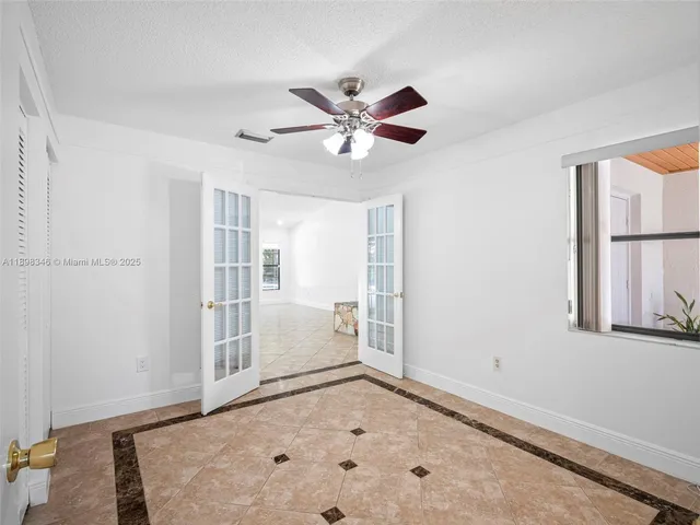 a view of a livingroom with a ceiling fan and a kitchen