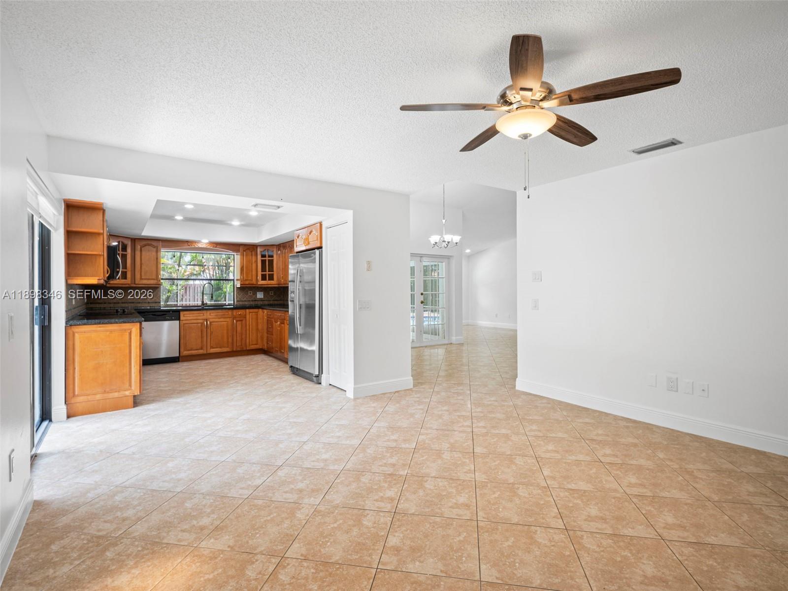 15531 Southwest 54th Terrace Miami, FL 33185 - Photo 25 of 61 a view of a livingroom with a ceiling fan and a kitchen