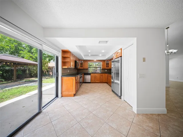 a view of a livingroom with a chandelier fan and windows