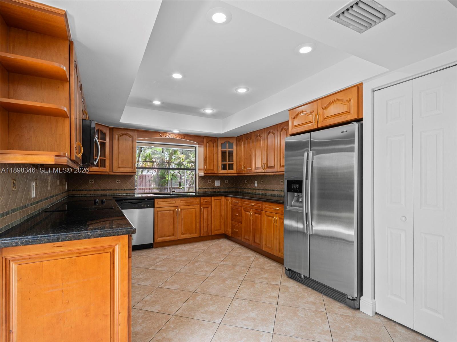 15531 Southwest 54th Terrace Miami, FL 33185 - Photo 28 of 61 a kitchen with stainless steel appliances granite countertop a refrigerator and a sink
