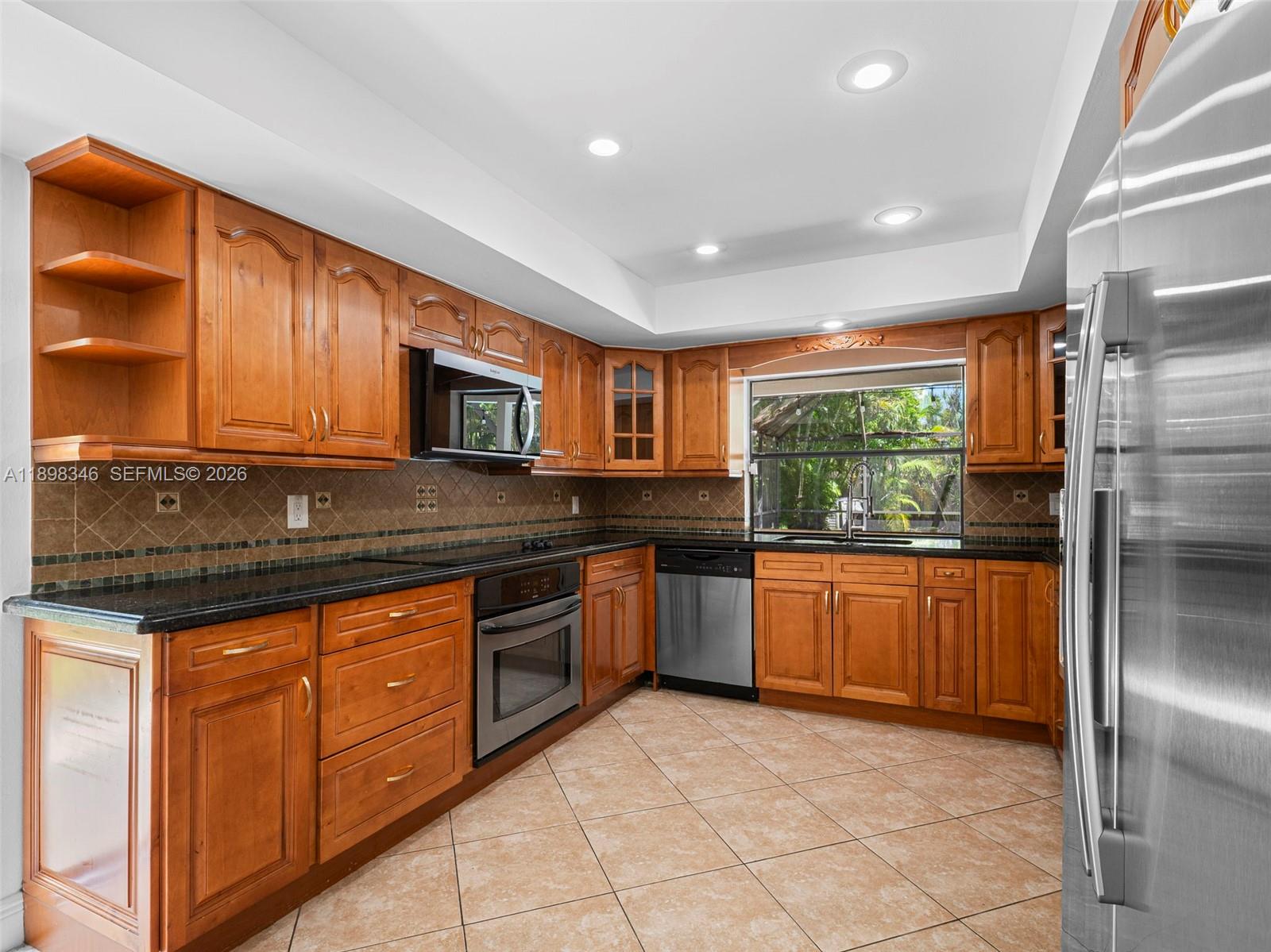 15531 Southwest 54th Terrace Miami, FL 33185 - Photo 29 of 61 a kitchen with stainless steel appliances granite countertop a stove a sink dishwasher a refrigerator and a microwave oven