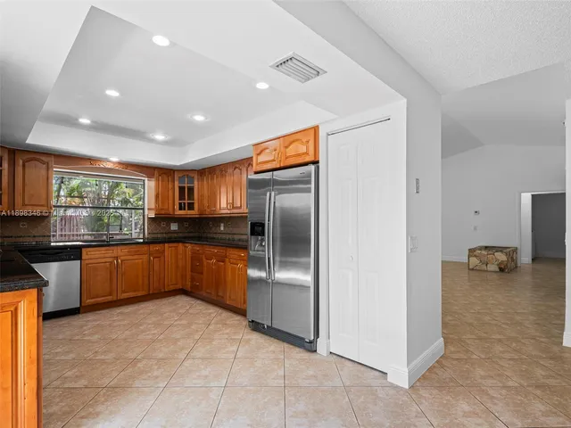 a view of a backyard with a garden and wooden fence