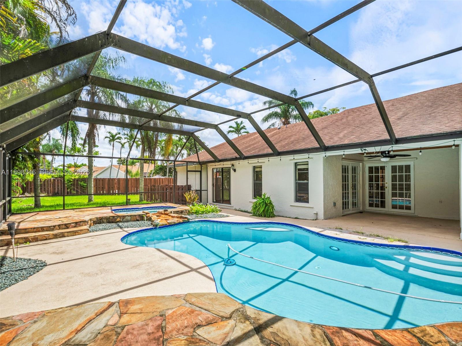 15531 Southwest 54th Terrace Miami, FL 33185 - Photo 40 of 61 a patio with a table and chairs under an umbrella