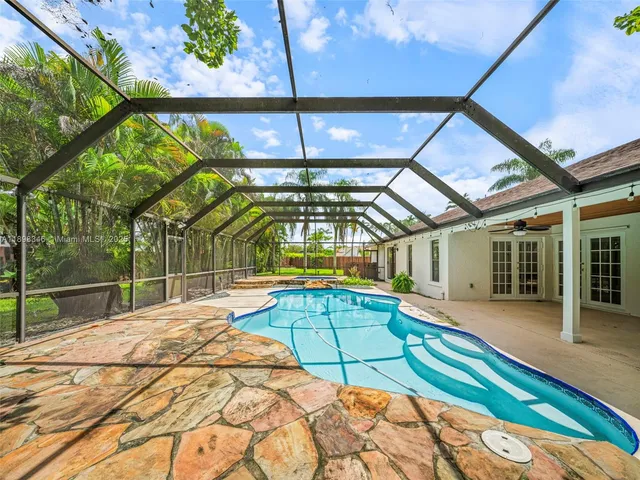 a view of a backyard with couches plants and large tree