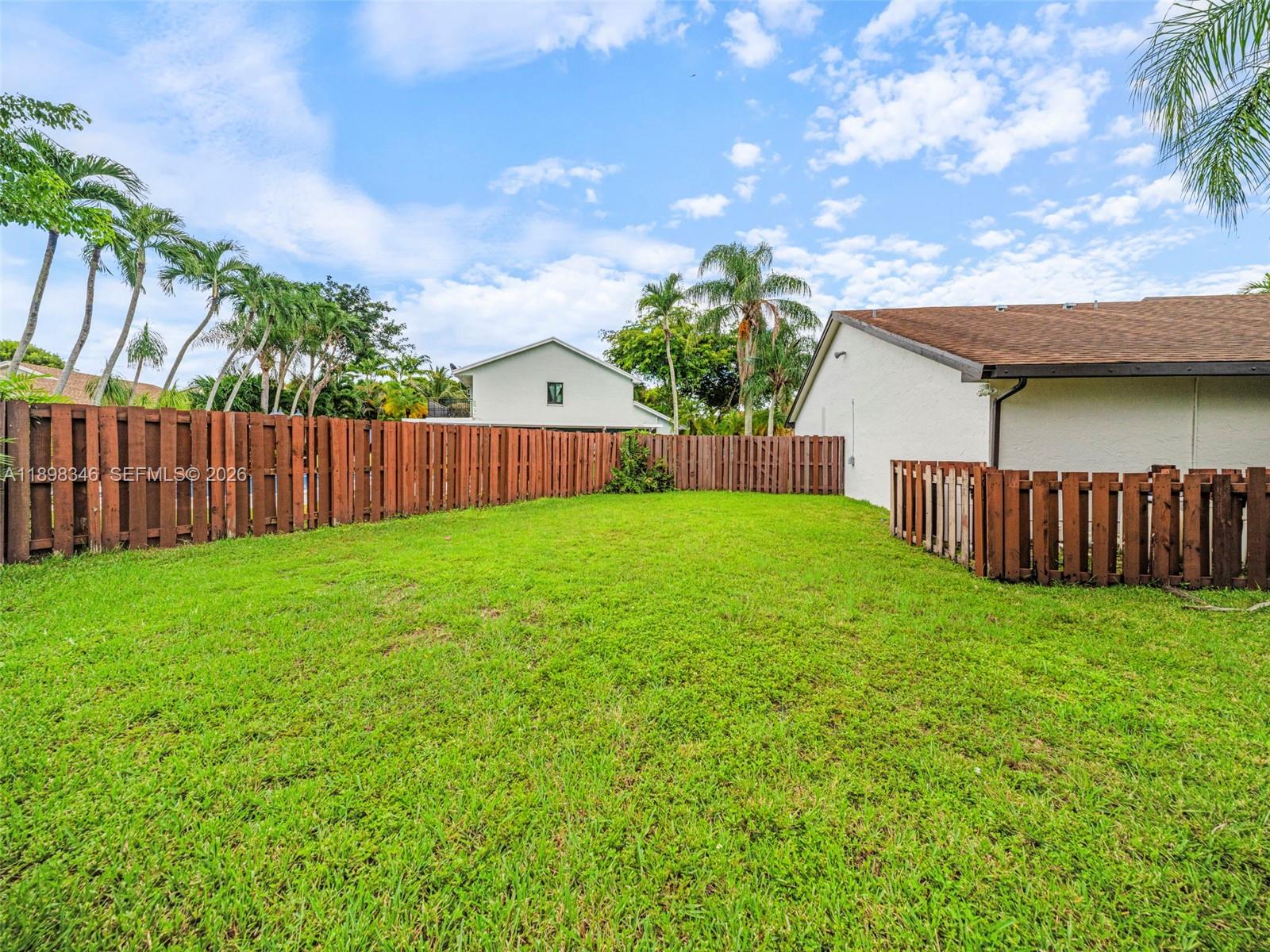15531 Southwest 54th Terrace Miami, FL 33185 - Photo 45 of 61 a view of a backyard with a garden and wooden fence