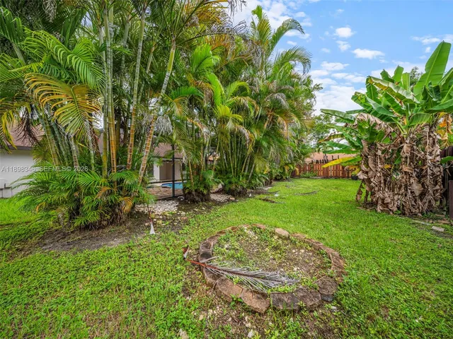 an aerial view of residential houses with outdoor space and trees