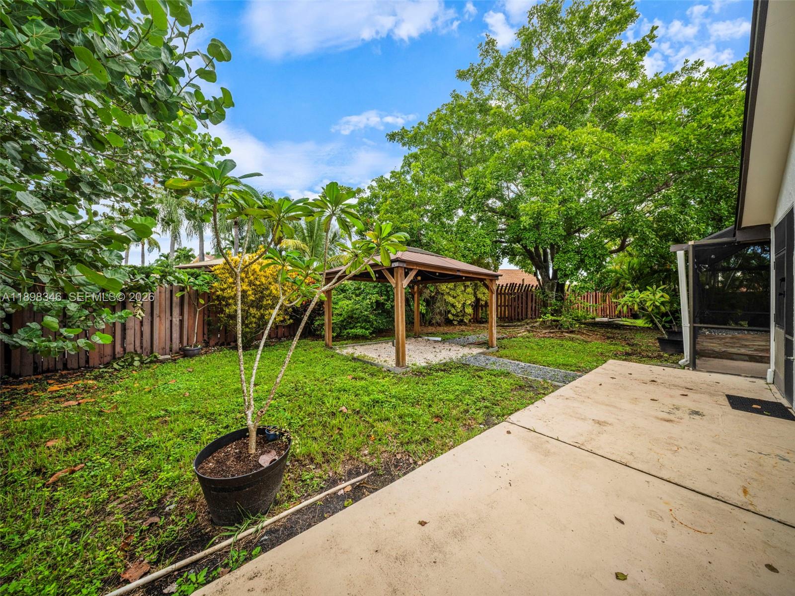 15531 Southwest 54th Terrace Miami, FL 33185 - Photo 50 of 61 a view of a backyard with couches plants and large tree