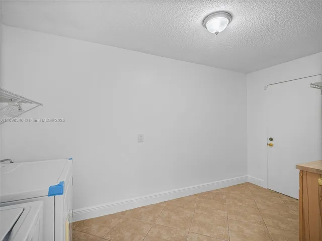 a large white kitchen with granite countertop a stove a sink and a refrigerator