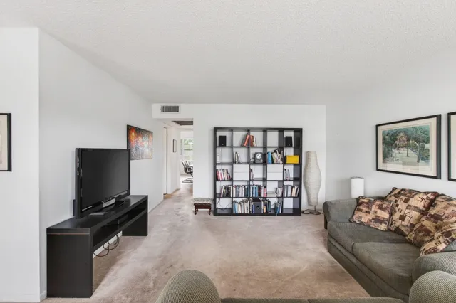 a living room with furniture and a book shelf