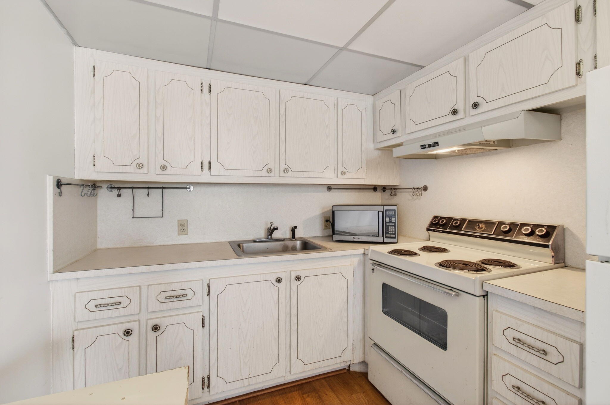 321 Fanshaw H Boca Raton, FL 33434 - Photo 17 of 92 a kitchen with granite countertop white cabinets and white appliances