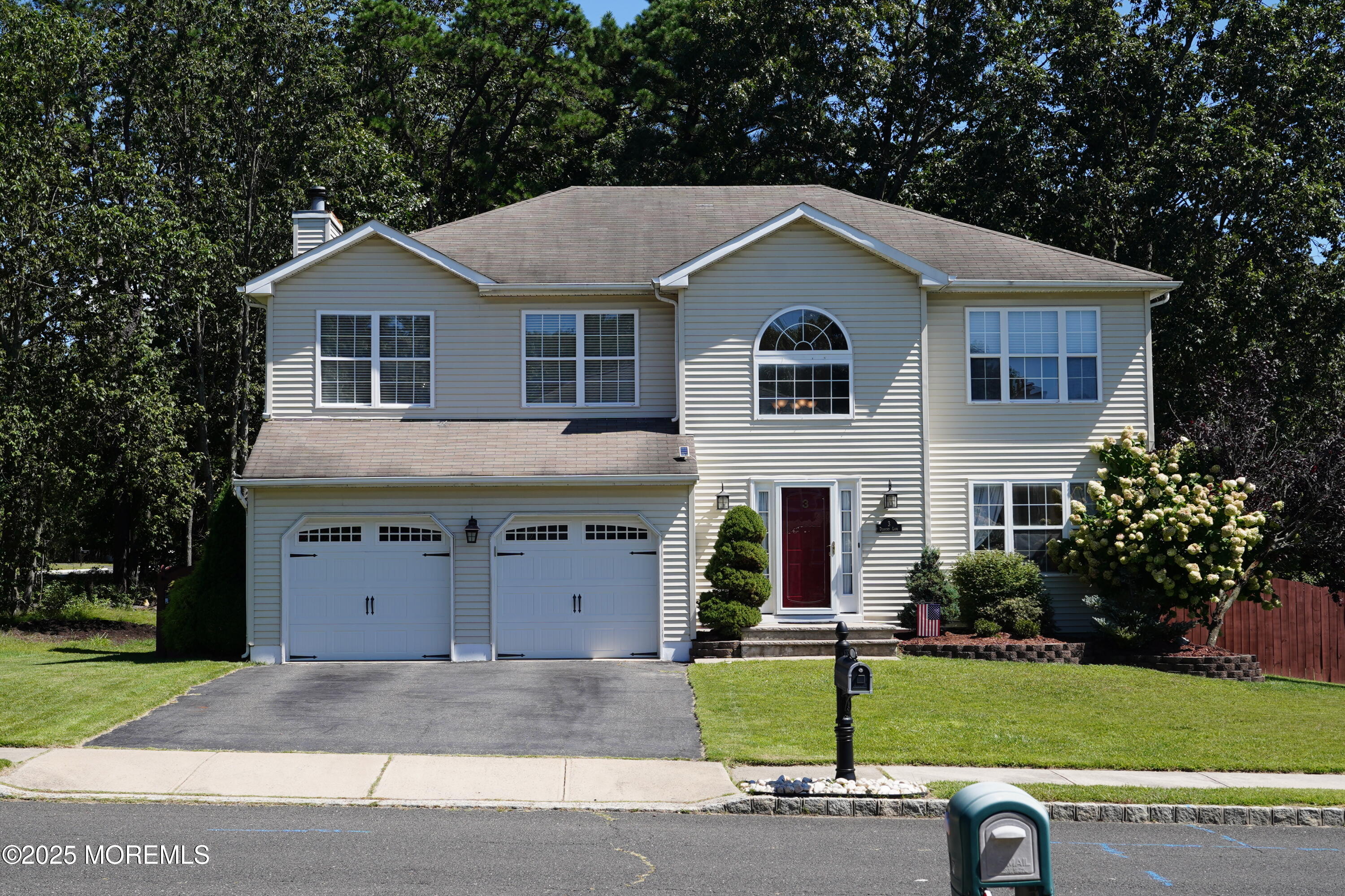a view of a house with a yard and large tree