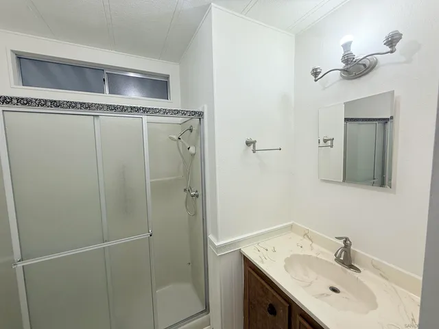 a bathroom with a sink a mirror and shower