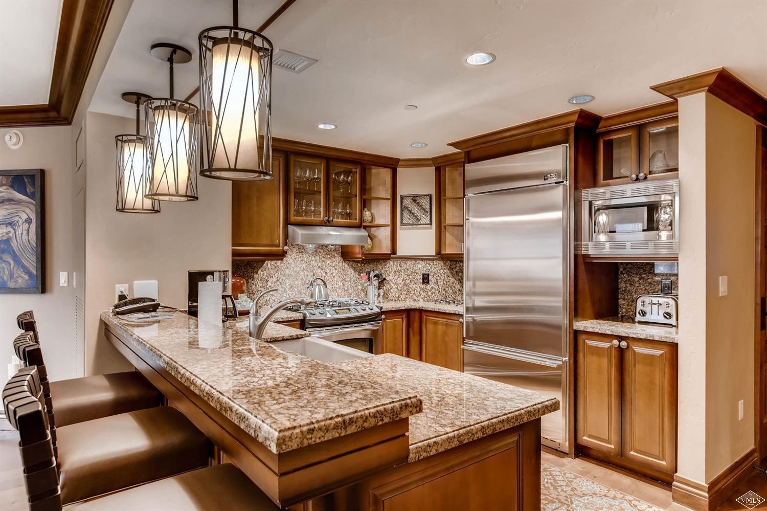 a kitchen with stainless steel appliances granite countertop a sink refrigerator and stove