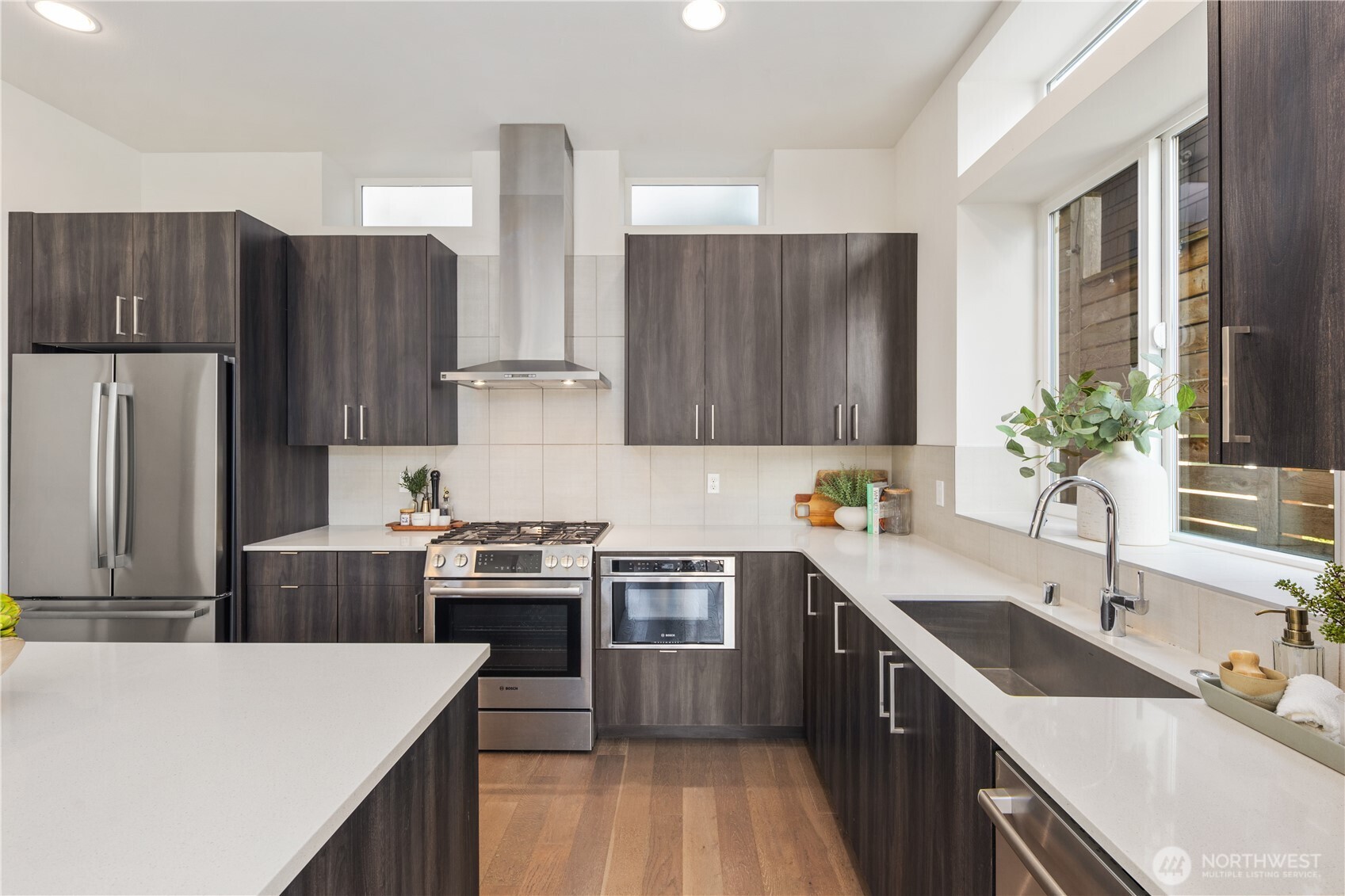 926 North 35th Street Seattle, WA 98103 - Photo 13 of 40 a kitchen with stainless steel appliances a sink a stove a refrigerator and a sink with wooden cabinets