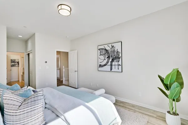 a bedroom with a bed and a potted plant