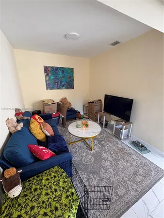 a living room with a rug and a coffee table