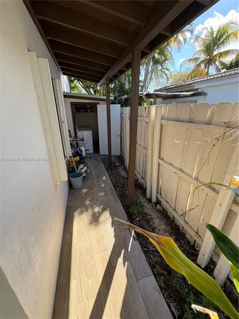 a view of a backyard with wooden floor and iron fence