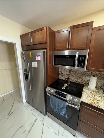 a kitchen with granite countertop stainless steel appliances and wooden cabinets
