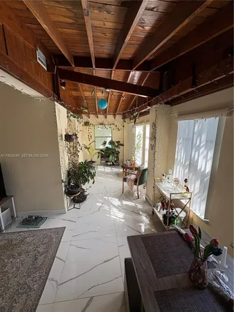 a living room with patio furniture and a chandelier