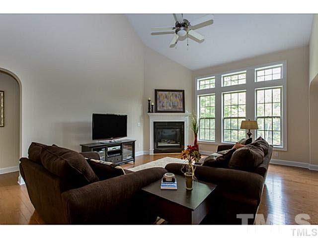 13028 Saxon Way Raleigh, NC 27613 - Photo 8 of 21 a living room with furniture a fireplace and a flat screen tv