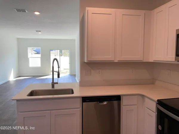 a view of a kitchen with wooden floor and a sink