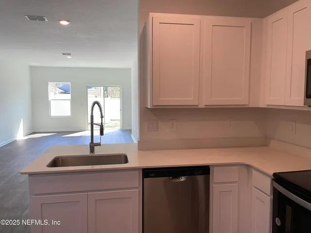 a view of a kitchen with wooden floor and a sink