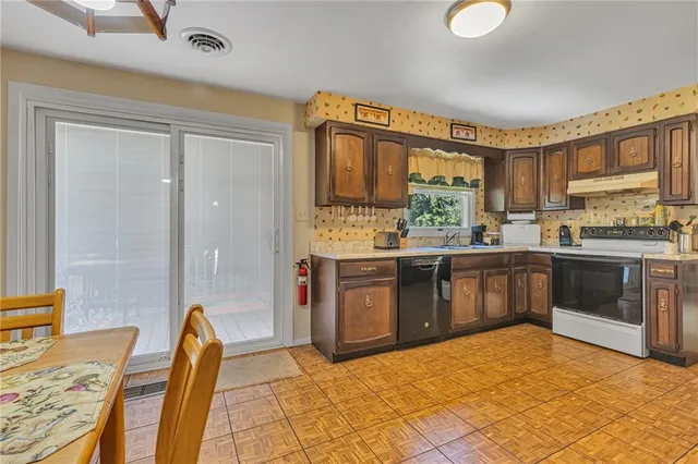 a kitchen with stainless steel appliances granite countertop a stove a sink and a refrigerator