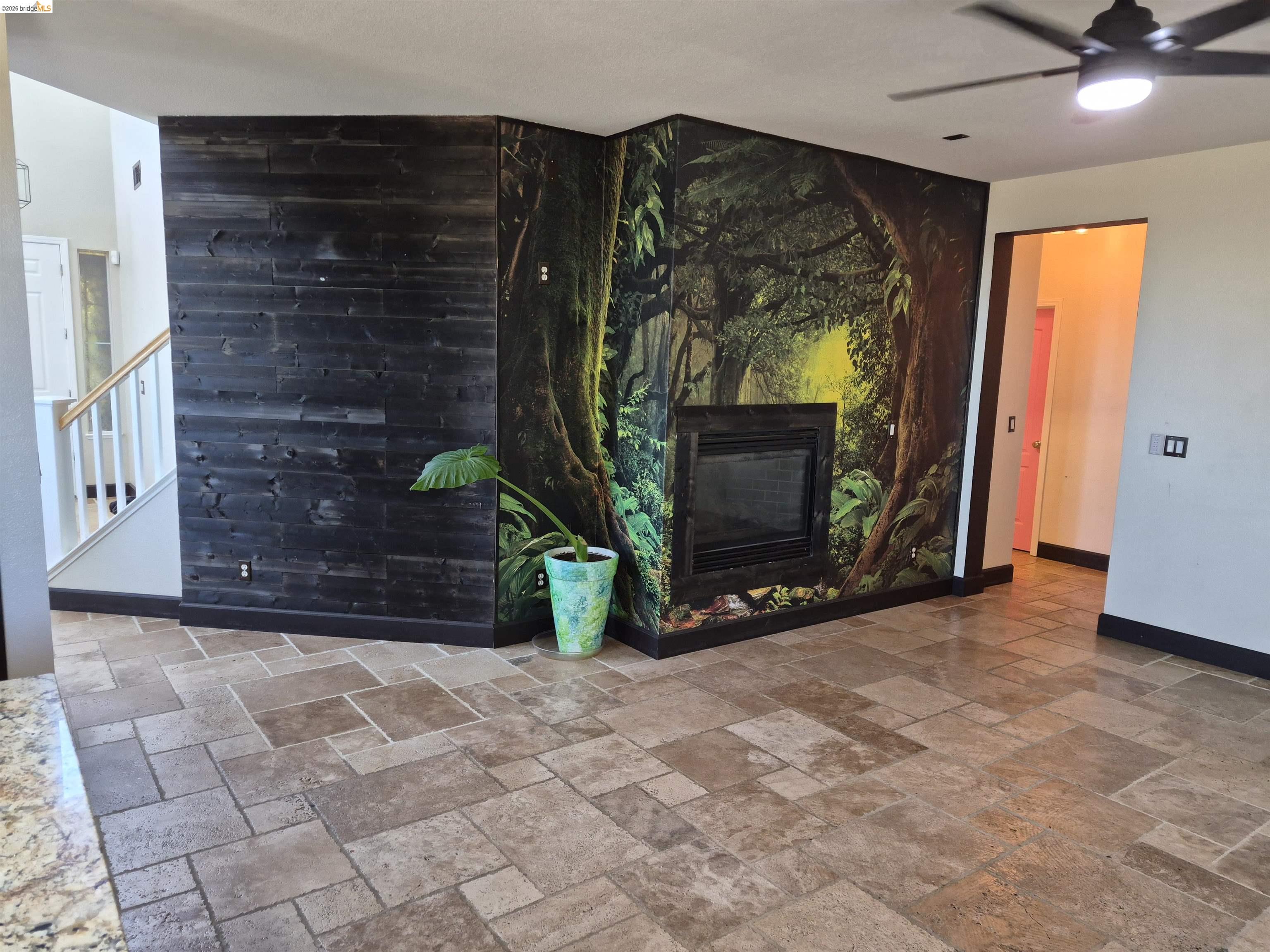 149 Oakpoint Court Bay Point, CA 94565 - Photo 4 of 22 Interior space featuring stone-look tile flooring, a built-in fireplace, and a wood plank accent wall