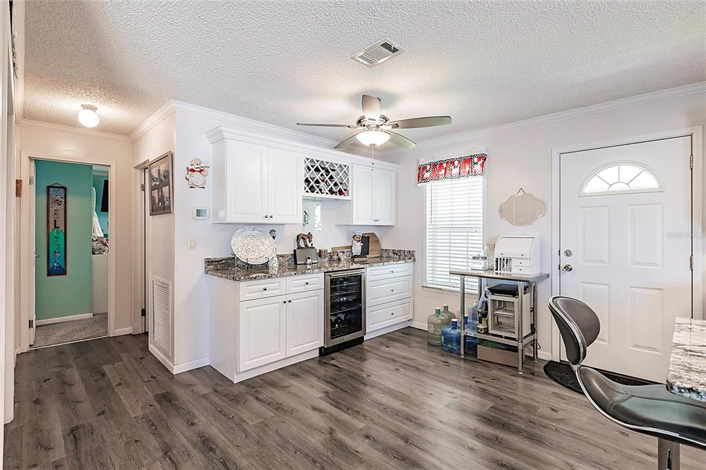 21 Rotterdam Punta Gorda, FL 33950 - Photo 7 of 40 a kitchen with a refrigerator a stove a dining table and chairs with wooden floor