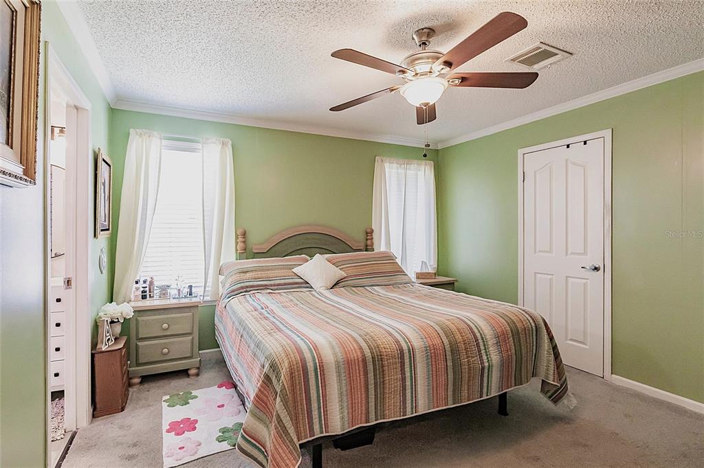 21 Rotterdam Punta Gorda, FL 33950 - Photo 9 of 40 a bedroom with a bed a chandelier and a window