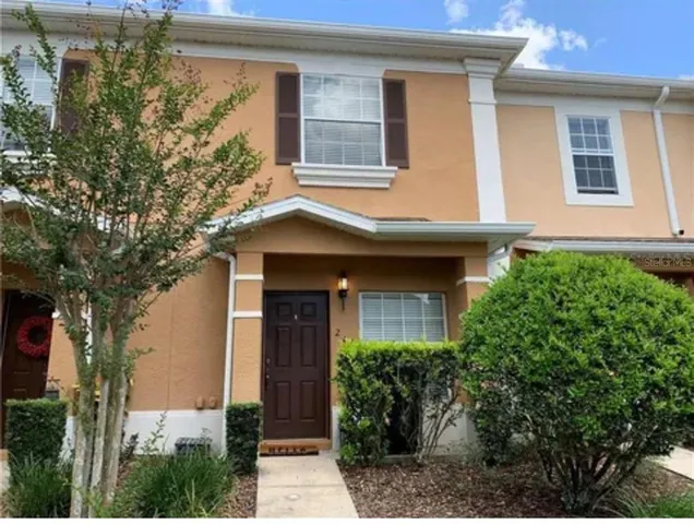 a front view of a house with plants