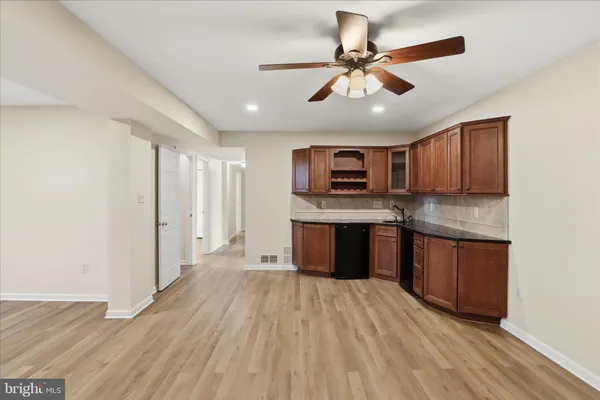 a kitchen with stainless steel appliances granite countertop a refrigerator a sink dishwasher a stove with wooden cabinets and floor