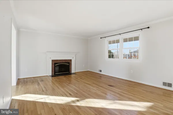 a view of empty room with wooden floor and fireplace