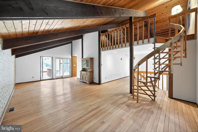 a living room with furniture and a dining table with wooden floor