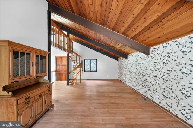 a kitchen with stainless steel appliances granite countertop a refrigerator a sink dishwasher a dining table and chairs with wooden floor