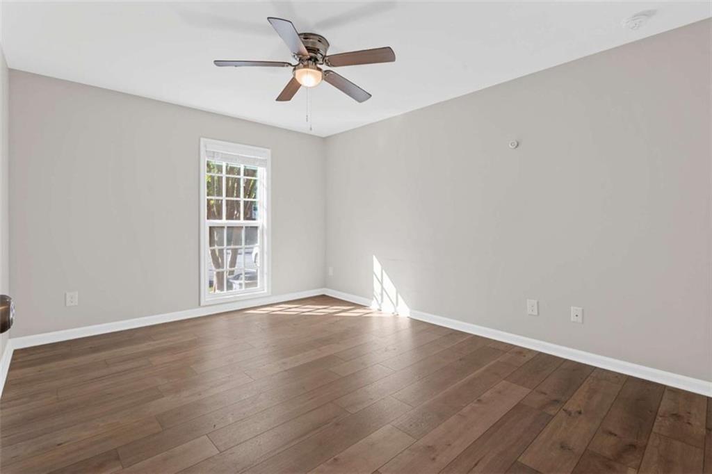 1166 Booth Road, Unit 407 Marietta, GA 30008 - Photo 17 of 18 a view of an empty room with a window and wooden floor