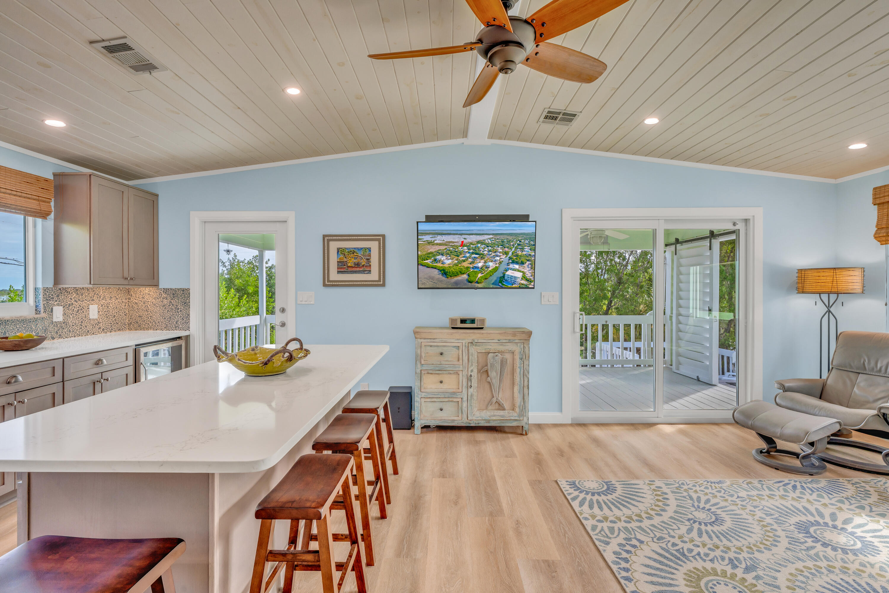 3987 Gordon Road Big Pine Key, FL 33043 - Photo 19 of 49 a open kitchen with stainless steel appliances granite countertop a stove a refrigerator a sink a dining table and chairs with wooden floor