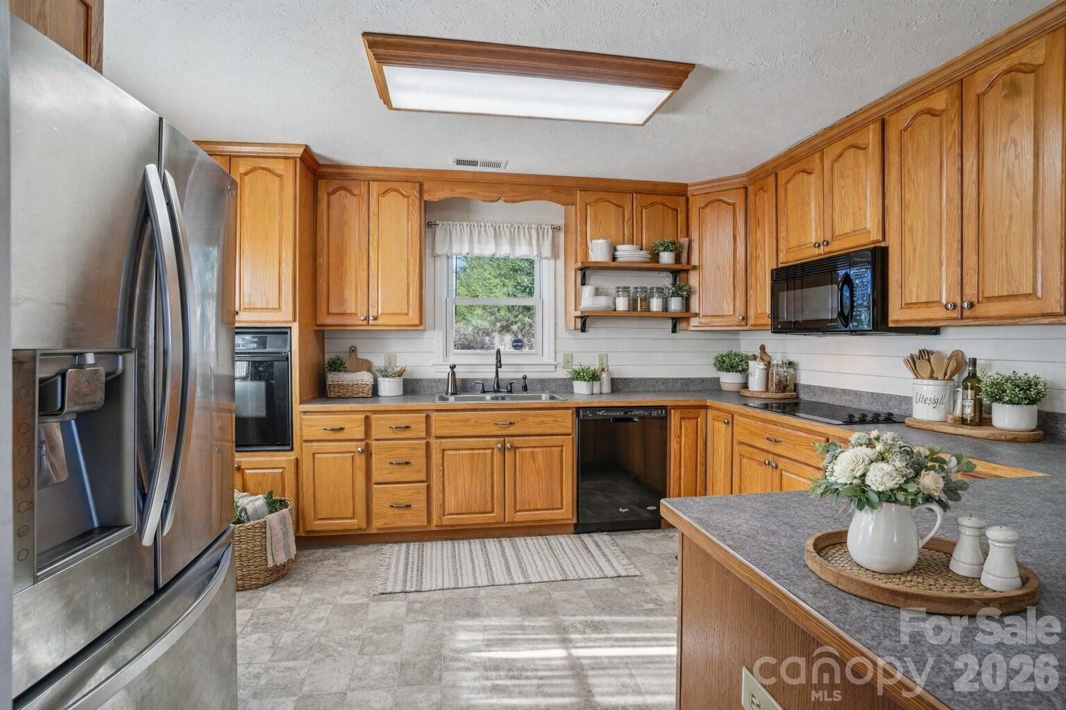 511 Oak Grove Road Flat Rock, NC 28731 - Photo 13 of 38 a kitchen with stainless steel appliances granite countertop a refrigerator sink and stove