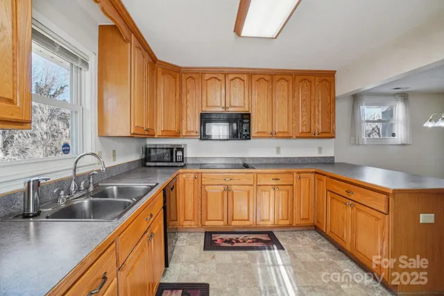 a kitchen with granite countertop wooden cabinets stainless steel appliances a sink and a window