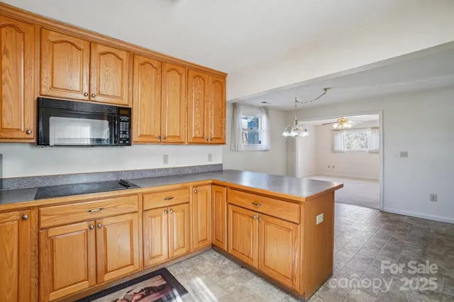 a kitchen with stainless steel appliances granite countertop a sink a stove and a microwave