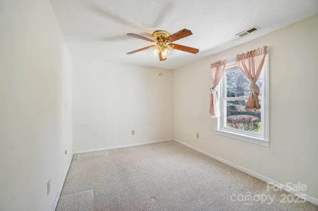 a view of empty room with ceiling fan