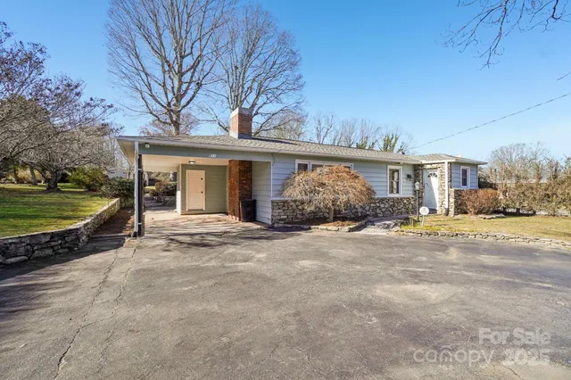 a view of a house with backyard and trees