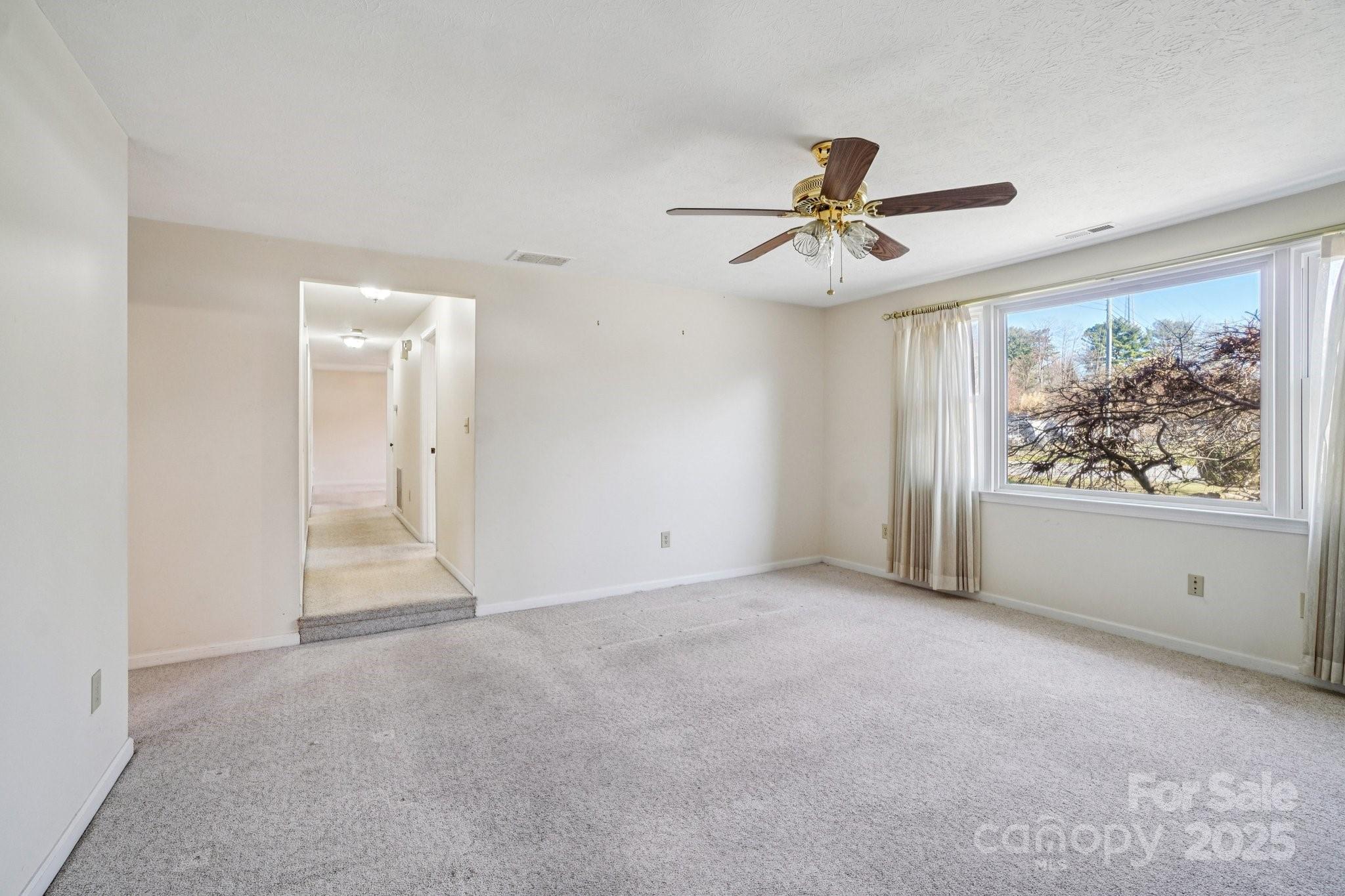 511 Oak Grove Road Flat Rock, NC 28731 - Photo 23 of 34 an empty room with chandelier fan and windows