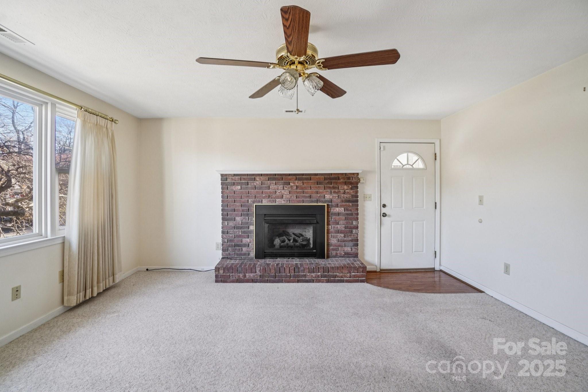 511 Oak Grove Road Flat Rock, NC 28731 - Photo 24 of 34 a view of an empty room with a fireplace and a window