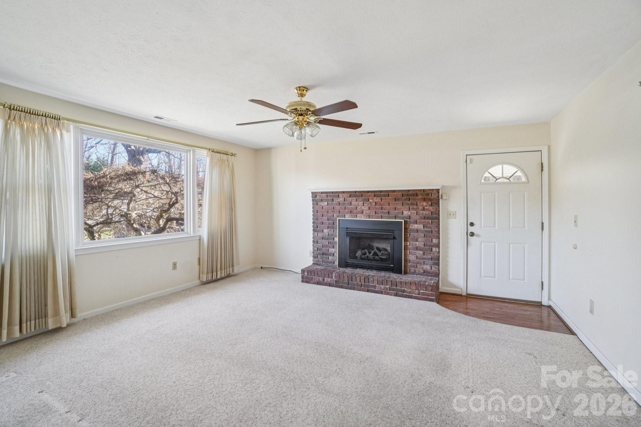 511 Oak Grove Road Flat Rock, NC 28731 - Photo 25 of 38 an empty room with fireplace and fan