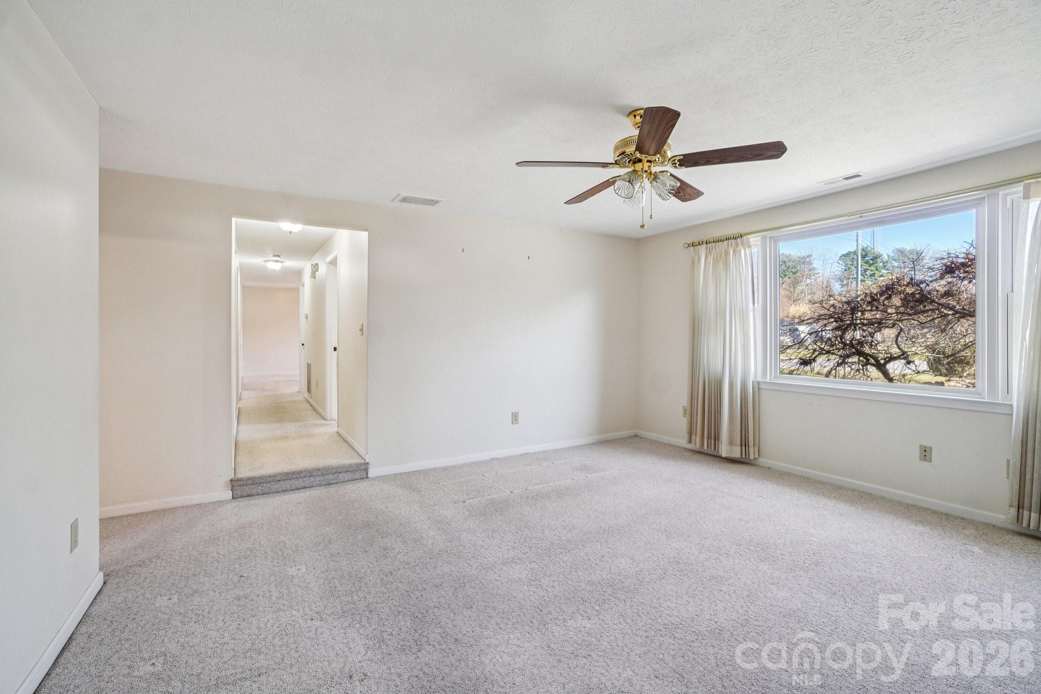 511 Oak Grove Road Flat Rock, NC 28731 - Photo 26 of 38 an empty room with chandelier fan and windows