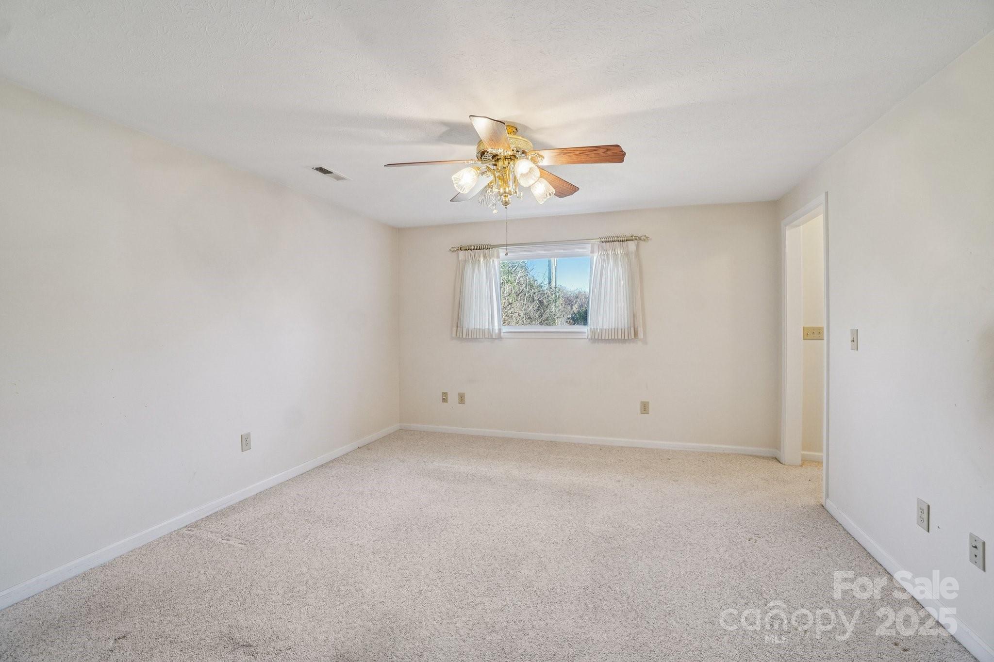 511 Oak Grove Road Flat Rock, NC 28731 - Photo 9 of 34 an empty room with a window and a chandelier fan