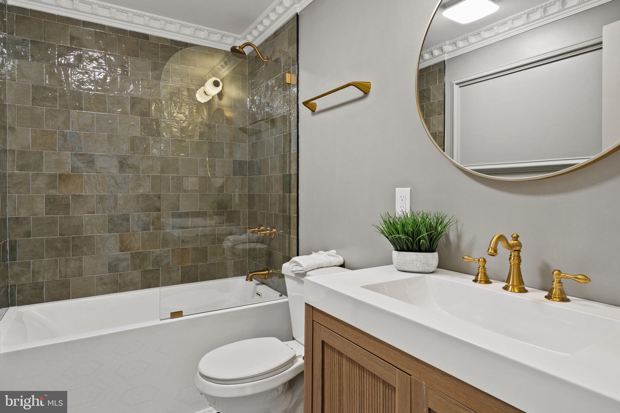 914 Fernon Street Philadelphia, PA 19148 - Photo 15 of 40 a bathroom with a granite countertop sink a toilet a mirror and shower