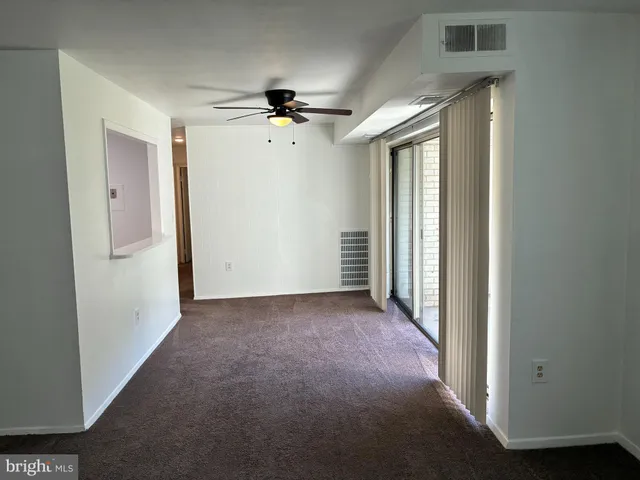 a view of a hallway with a chandelier fan and windows